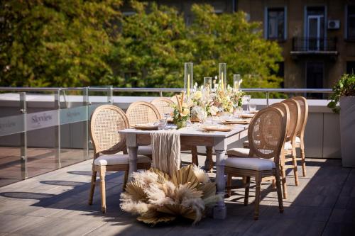 a table with chairs and flowers on a balcony at Sheraton Bucharest Hotel in Bucharest