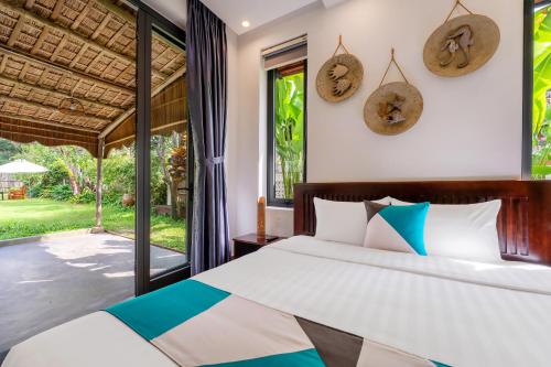 a bedroom with a bed and a large window at An Bang Seascape Homestay in An Bang