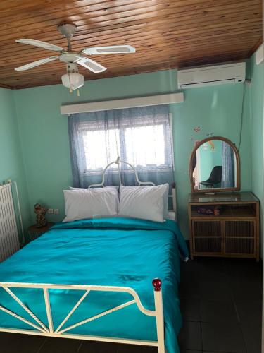 アイイ・テオドリにあるKrista's houseの青いベッドルーム(ベッド1台、鏡付)
