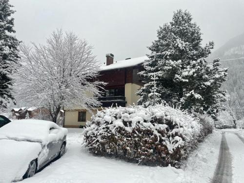 a car covered in snow in front of a house at Haus Karin Mallnitz in Mallnitz
