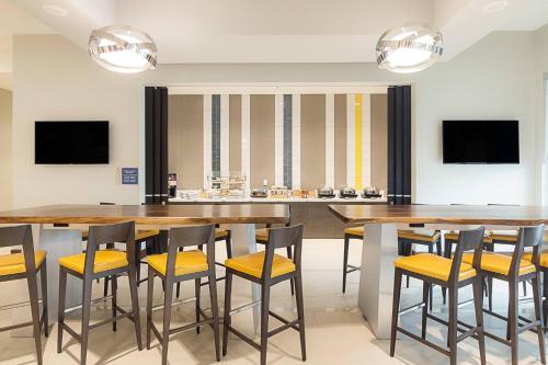 a dining room with a large table and stools at SpringHill Suites by Marriott Fort Worth Fossil Creek in Fort Worth