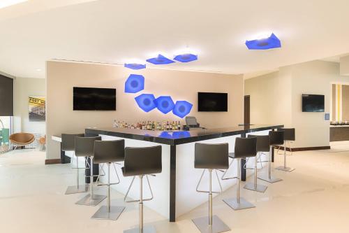 a bar in a room with chairs and blue vases at SpringHill Suites by Marriott Fort Worth Fossil Creek in Fort Worth
