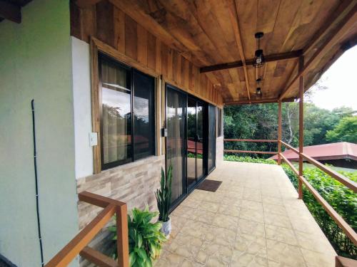 un porche de una casa con techo de madera en Las Marias Mountain View Cottages, en Monteverde