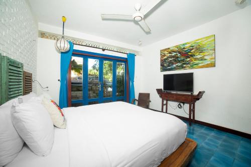 An Bàn (2)にあるLoft House 2BR Beachside An Bang Beach Hoi An by Beachside Boutique Homesの白いベッドとテレビのある寝室