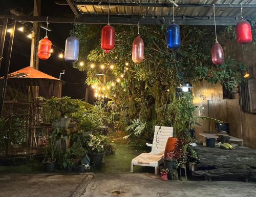 a room with colorful lights and plants and a couch at เอนกายสบายรีสอร์ต in Ban Tha Nang Hom (1)