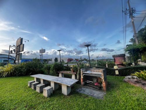 a park with a bench and a table in the grass at เอนกายสบายรีสอร์ต in Ban Tha Nang Hom (1)