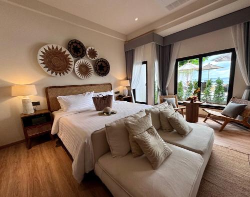 a bedroom with a large bed and a couch at Baan Haad Ngam Boutique Resort in Chaweng