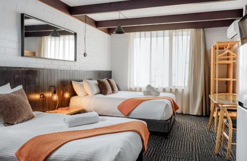 een hotelkamer met 2 bedden en een spiegel bij m hotel in Sale