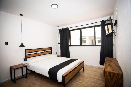 1 dormitorio con cama y ventana grande en Casa Maca en Playa del Carmen