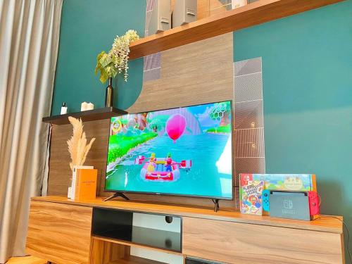 a flat screen tv sitting on top of a wooden entertainment center at imperium residence kuantan in Kuantan