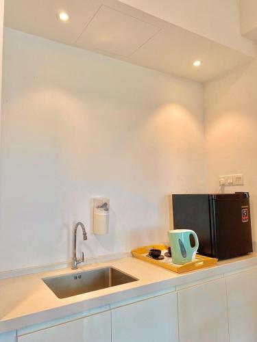 a kitchen with a sink and a microwave at imperium residence kuantan in Kuantan