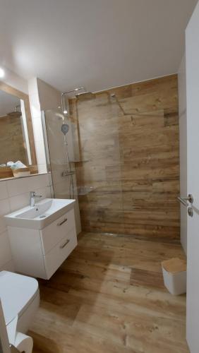 a bathroom with a shower and a toilet and a sink at Ferienwohnung Bergblume in Bolsterlang