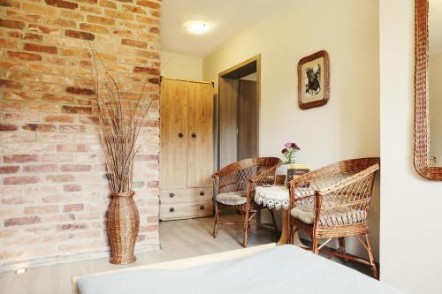 a room with a table and chairs and a brick wall at Bednarzówka in Nowy Tomyśl