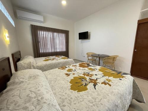 Hotel Allende في لاباز: غرفة فندقية بسريرين وطاولة