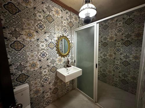 uma casa de banho com um lavatório, um chuveiro e um espelho. em Shawn's Transient House at New Clark City em Calingcuan