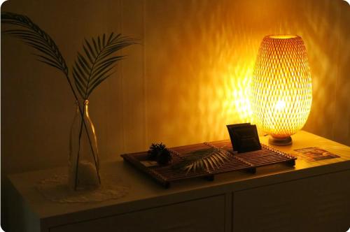 a table with a lamp and a plant on it at Gaon guesthouse in Jeonju