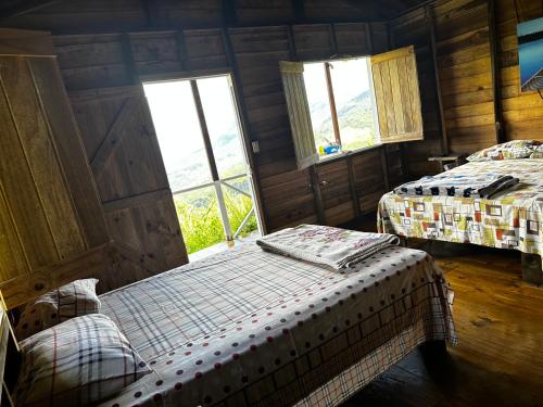 1 dormitorio con 2 camas y ventana en Vista Paraíso Lodge, en Barú
