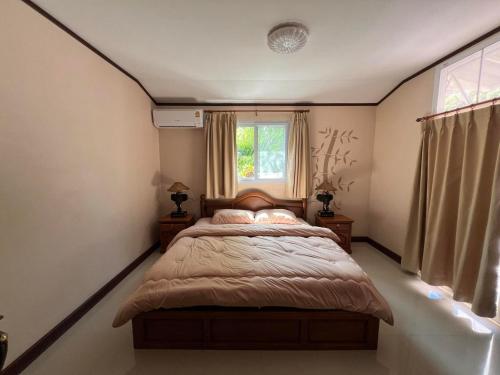 a bedroom with a bed and a window at Khaolak 2K Pool Villa in Khao Lak
