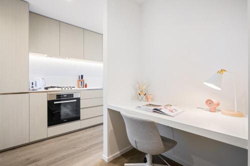 墨爾本的住宿－Prestige Living in Southbank，厨房配有白色橱柜和桌椅