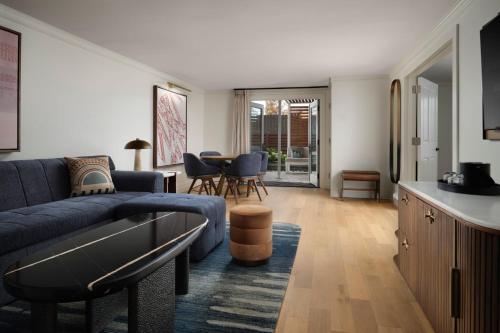 a living room with a blue couch and a table at The Union Station Nashville Yards, Autograph Collection in Nashville