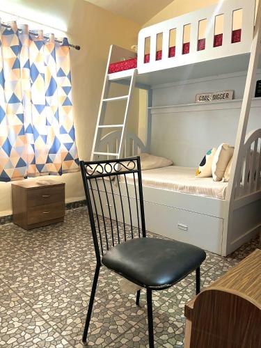 a bedroom with bunk beds with a chair and a ladder at You are the key Villa in Anjuna