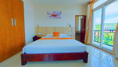 een slaapkamer met een bed en een groot raam bij Victoria Phu Quoc hotel 1 minute walking to beach, near to night market in Phu Quoc
