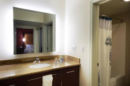 baño con lavabo y espejo grande en Residence Inn Lafayette Airport, en Lafayette