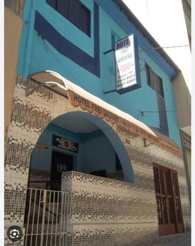 a blue building with a sign on the side of it at Hotel Frei Galvão in Aparecida