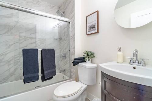 a bathroom with a toilet and a shower and a sink at McCormick Place 420 friendly 3BR/2BA with Optional parking for up to 8 guests in Chicago