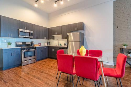 a kitchen with a table and red chairs in it at South Loop 3BR Group Comfort Near Downtown, Grant Park, Soldier Field and McCormick Place in Chicago
