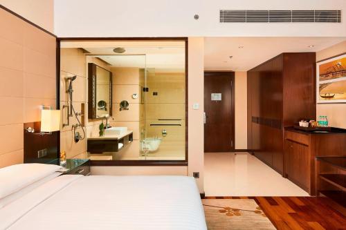 1 dormitorio con 1 cama y baño con lavamanos en Kochi Marriott Hotel, en Kochi