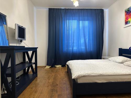 1 dormitorio con cama y cortina azul en Guculka, en Yaremche