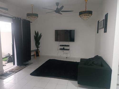 sala de estar con sofá y TV de pantalla plana en Homestay an nur, en Kuantan