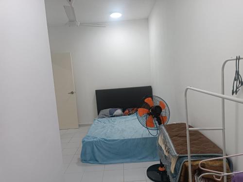 1 dormitorio con 1 cama y ventilador. en Homestay an nur, en Kuantan