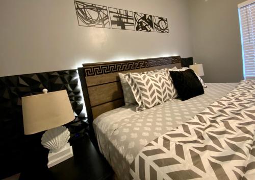 a bedroom with a bed with a black and white comforter at Elegant Parisian Home near Fondren in Jackson