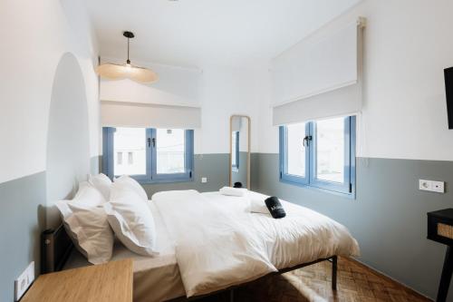 a bedroom with a bed with white sheets and pillows at CANVAS Color Your Stay in Volos