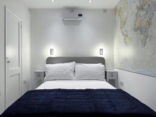 1 dormitorio con 1 cama grande y un mapa en la pared en Kensington Studio hosted by AirOperate near Notting Hill - 1 Double Bed , 1 Sofa Bed, Ground Floor Apartment via Private Entrance en Londres