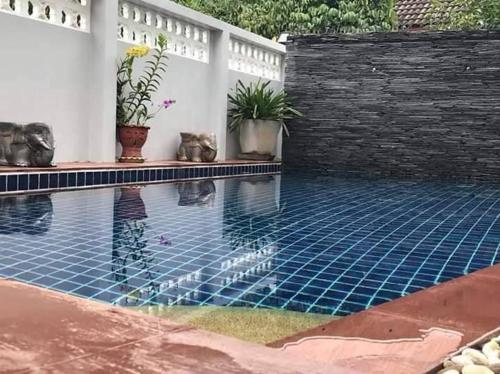 a swimming pool in a backyard with a brick wall at Mountain View Guest House in Phatthalung