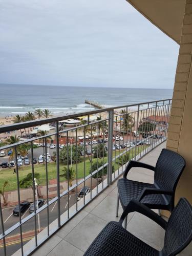 a balcony with chairs and a view of the beach at NO: 75 WINDEMERE HOLIDAY FLAT in Durban
