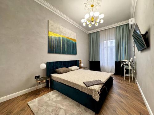 a bedroom with a large bed and a chandelier at Deribasivska 10 Luxury Apartment in Odesa
