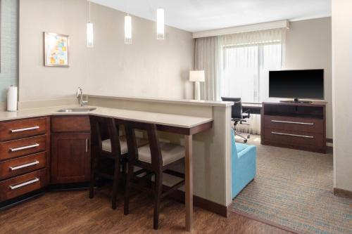 a room with a kitchen with a sink and a desk at Residence Inn by Marriott Boston Burlington in Burlington