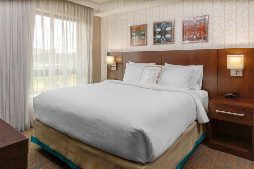 a large bed in a hotel room with a window at Residence Inn by Marriott Boston Burlington in Burlington