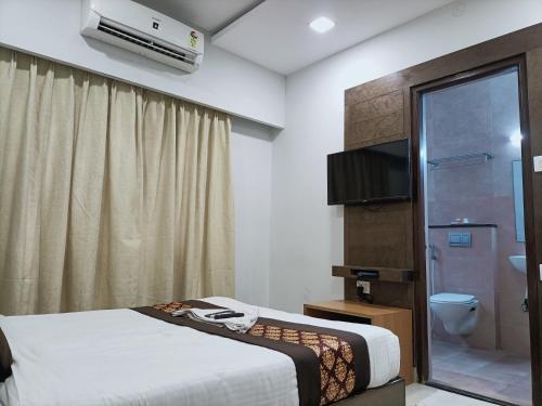 a hotel room with a bed and a bathroom at Hotel Zain Grande in Chennai