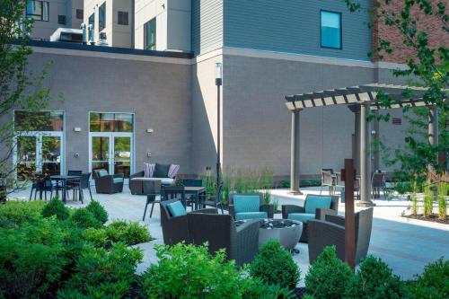a patio with chairs and tables in front of a building at Residence Inn by Marriott Boston Burlington in Burlington