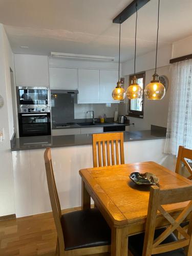 kuchnia z drewnianym stołem i jadalnią w obiekcie Haus Residence Wohnungen ground floor 003 w mieście Täsch