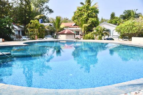 a large swimming pool with blue water at You are the key Villa in Anjuna