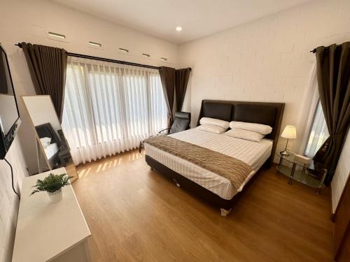 1 dormitorio con cama y ventana grande en Villa Putih Le Cordon, en Bandung