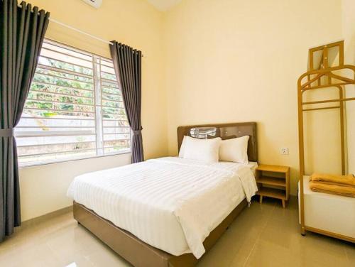 Un dormitorio con una cama grande y una ventana en Lovina B2/12A at Ansley Park Spacious+Netflix en Batam Centre
