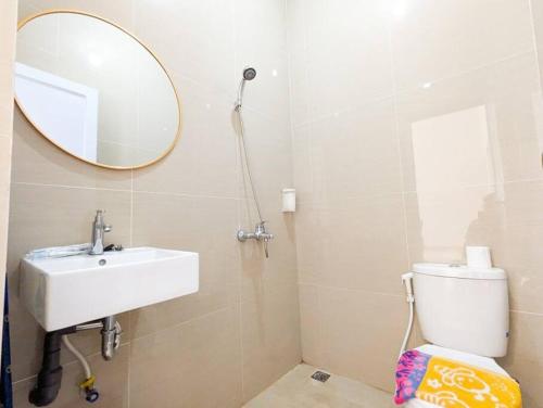 uma casa de banho com um lavatório, um espelho e um WC. em Lovina B2/12A at Ansley Park Spacious+Netflix em Batam Center