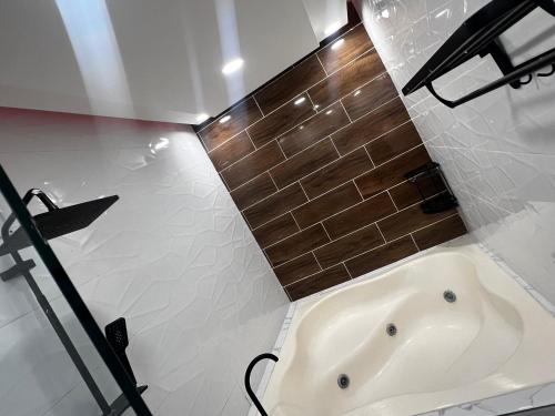 bagno con vasca e parete piastrellata marrone di Acogedor y moderno Spot para parejas! a Pantoja